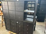 une grande armoire noire à tiroirs dans un entrepôt