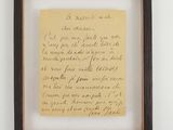 an old handwriting on a piece of paper hangs in a wooden frame