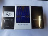 trois boîtes de parfum posées sur une table blanche