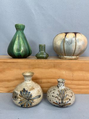 trois vases posés les uns à côté des autres sur une étagère en bois