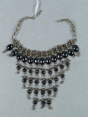 a close up of a necklace on a white surface