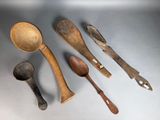 several wooden spoons and spoon knives are lined up on a table