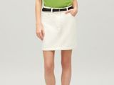 woman in a green shirt and white skirt posing for a picture