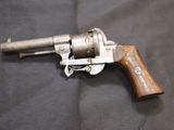 an old revolver with a wooden handle on a black cloth