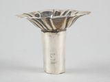 a silver vase with a flower design on the top of it