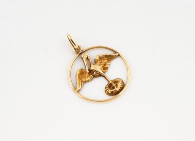 a close up of a gold pendant with a bird in a circle