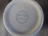 a close up of a white cup with a blue design on it