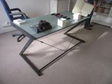a man standing in front of a desk with a laptop on it