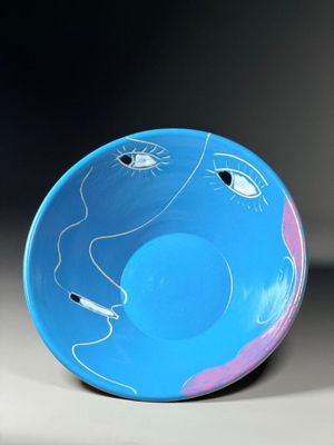 a blue bowl with a drawing of a face on it