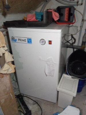 un petit réfrigérateur blanc dans une pièce encombrée