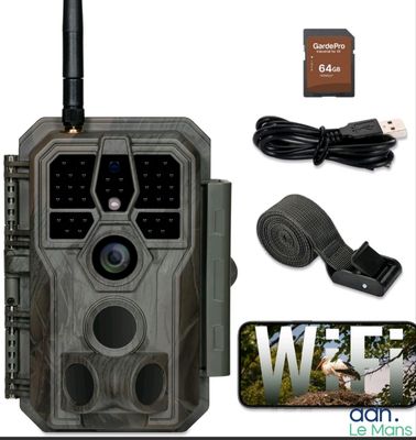 une photo d'une caméra de surveillance de sentier accompagnée d'un chargeur et d'autres accessoires