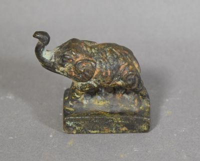statue d'un éléphant posé sur un rocher, avec un oiseau sur son dos