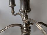 a silver candle holder with two candles on top of it