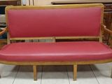 a red couch with a wooden frame and a red leather seat
