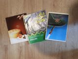 three books on a table with a cup of coffee on top of it