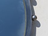 a mirror on the side of a building with a sky in the background