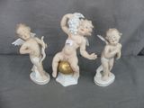 trois figurines de chérubins tenant une boule dorée