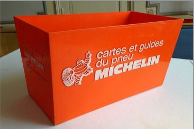 une boîte orange posée sur une table, sur laquelle figure un logo