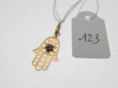une petite main de Hamsa en or ornée d'une pierre noire