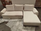a couch and ottoman in a room with a lot of boxes