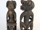 pair of wooden figures of a monkey and a monkey sitting on a stool