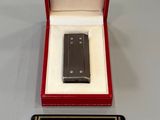 un téléphone portable noir dans une boîte rouge posée sur une table