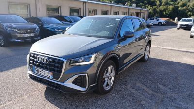 L'Audi QX est garée sur un parking, avec d'autres voitures en arrière-plan.