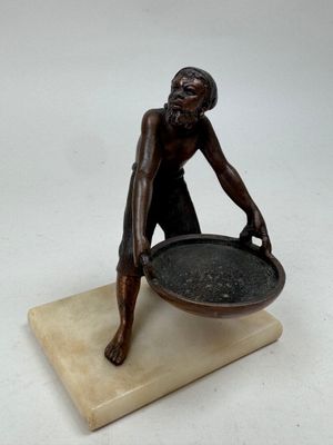 statue of a man holding a bowl on a marble base