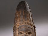 a close up of a wooden mask with a face on it