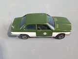 a green toy car that is sitting on a white surface