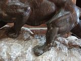 a statue of a bear on a rock in front of a wooden door