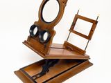 a wooden desk with a mirror and a chair on it