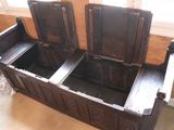 a wooden bench with two open seats in a room