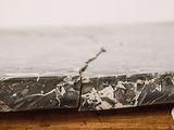 a close up of a marble top on a wooden table
