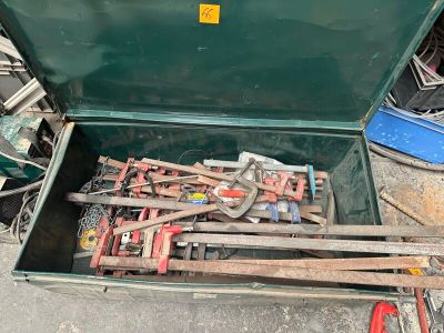 a green box with tools inside of it on the ground