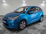 une voiture bleue est garée dans une pièce au sol à carreaux