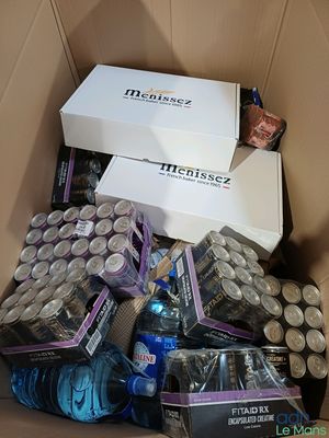 une boîte en carton remplie de canettes et encore de canettes de soda