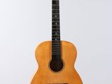 an acoustic guitar hanging from a string on a white background