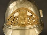 a gold helmet with a crest on it on a stand