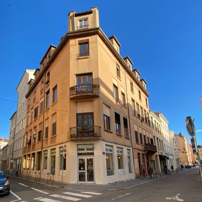 une voiture qui roule dans la rue devant un immeuble