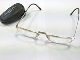 une paire de lunettes posée sur une surface blanche, avec un étui en arrière-plan