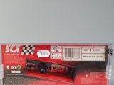 the box of a toy car is sitting on a white surface