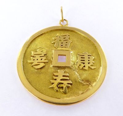 un gros plan d'une pièce d'or sur laquelle figurent des caractères chinois