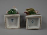 pair of porcelain figurines of a man and a woman sitting on a bench