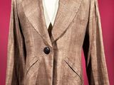 brown blazer on a mannequin stand against a red background