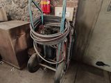 un chariot équipé d'un tuyau et d'un extincteur, à côté d'un mur de briques