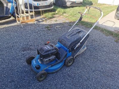a lawn mower that is sitting on the gravel