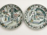 two plates with a painting on them are sitting on a table