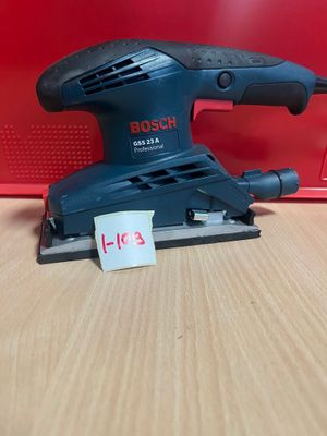 une ponceuse orbitale Bosch posée sur une table, avec son étiquette de prix