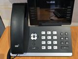 un téléphone posé sur un bureau à côté d'un bloc-notes